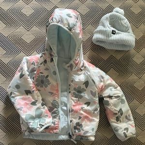 Reversible North Face coat with blue beanie.